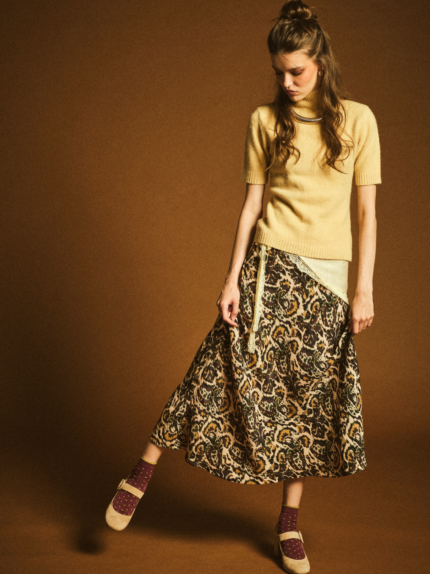 Editorial studio look: butter yellow knit with a printed bias-cut midi skirt
