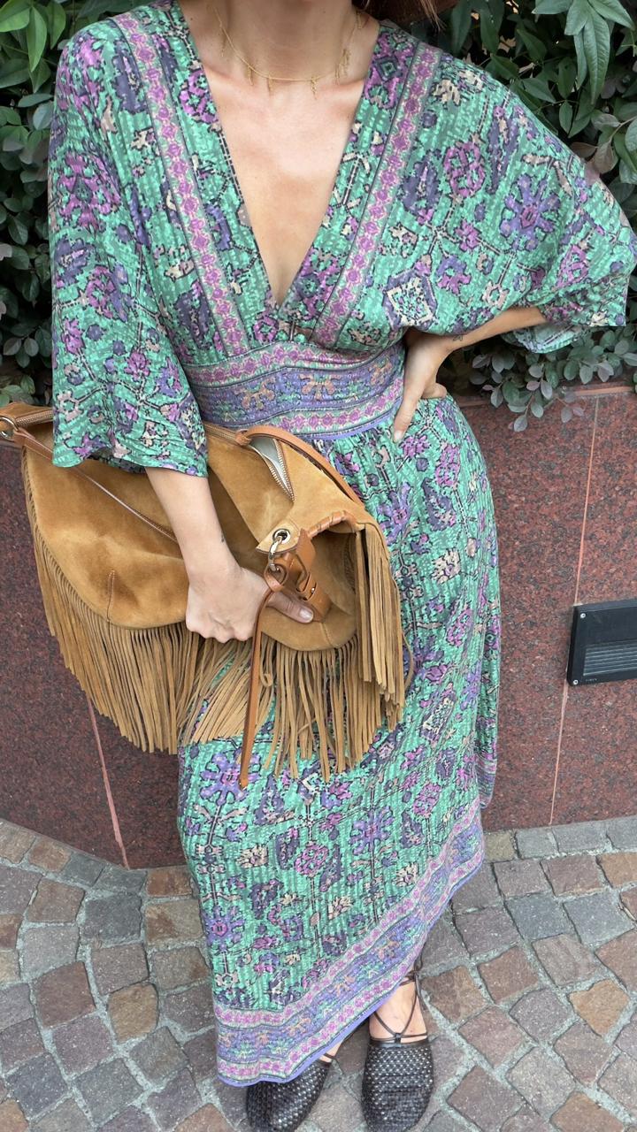 Styling detail: printed green and violet maxi dress with a tan fringed suede bag